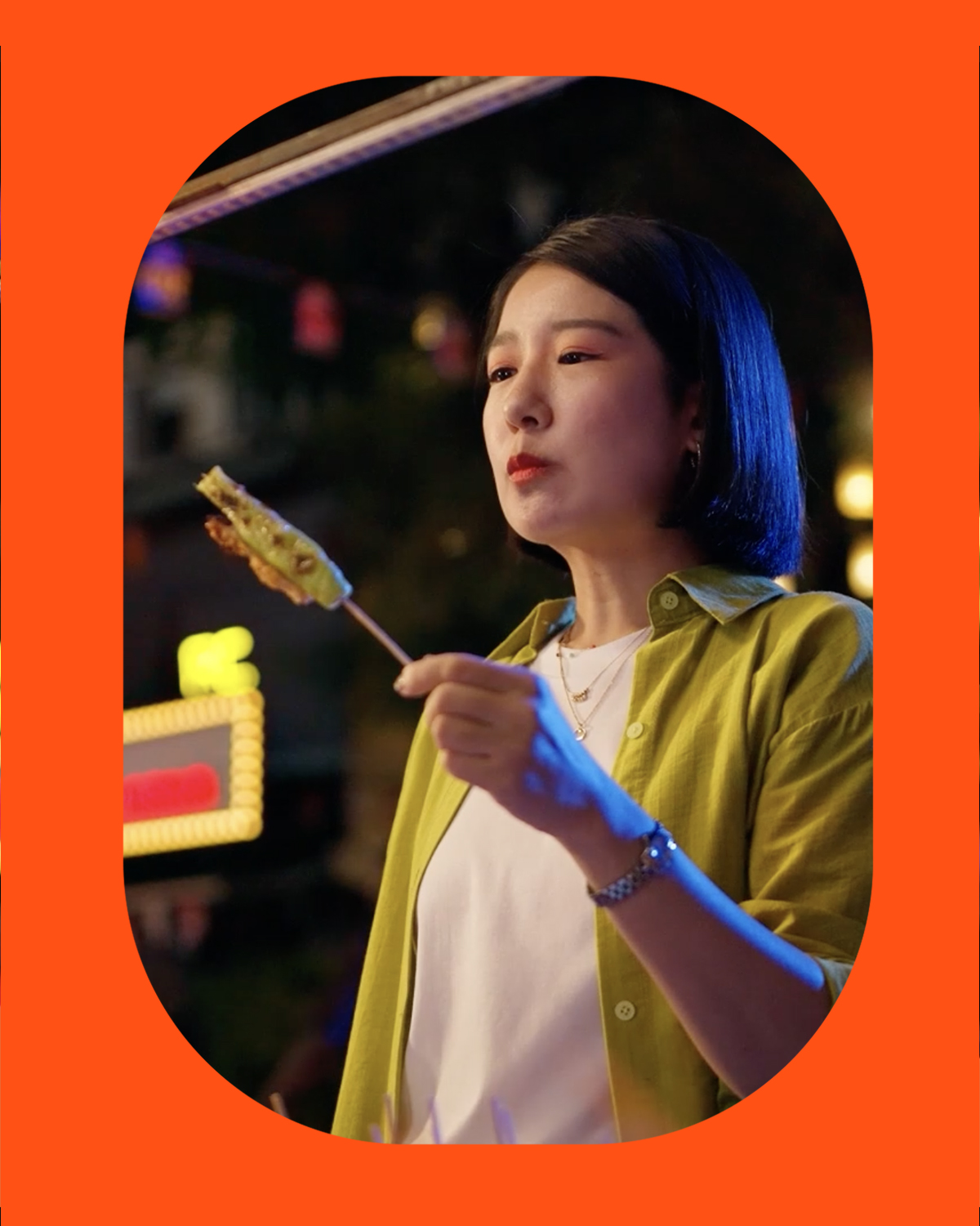 Night-market travel imagery contained in the orange window frame.